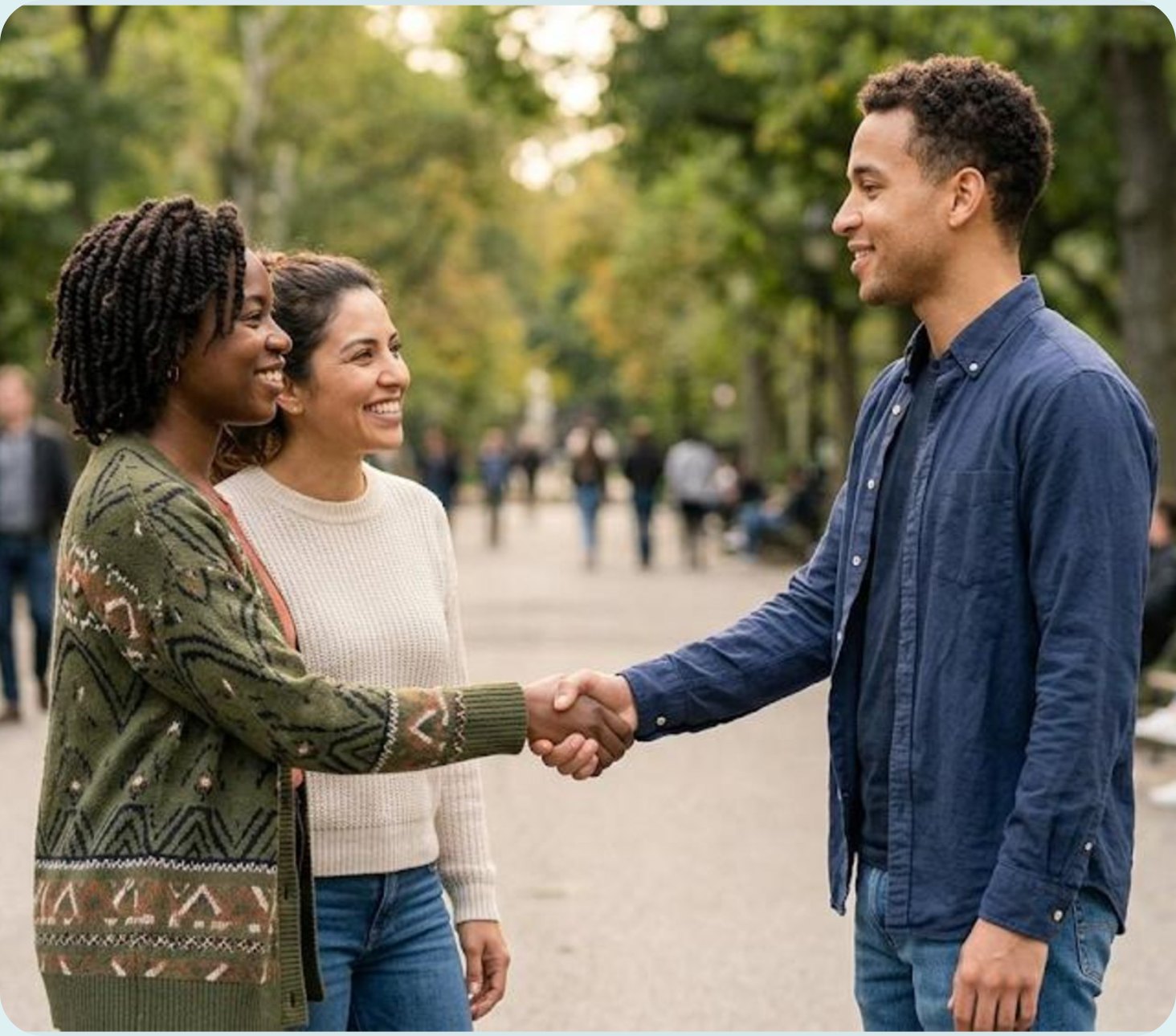 Three friends standing together in a park, smiling